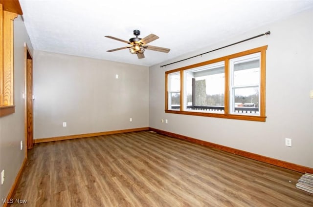 empty room featuring light wood-style floors, baseboards, and a ceiling fan