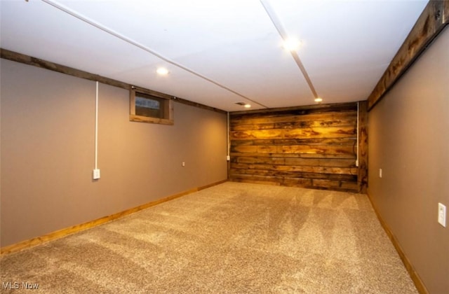 finished basement featuring baseboards, recessed lighting, carpet flooring, and wooden walls