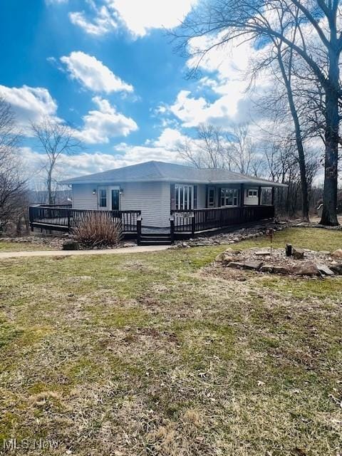 manufactured / mobile home featuring a front lawn and a wooden deck