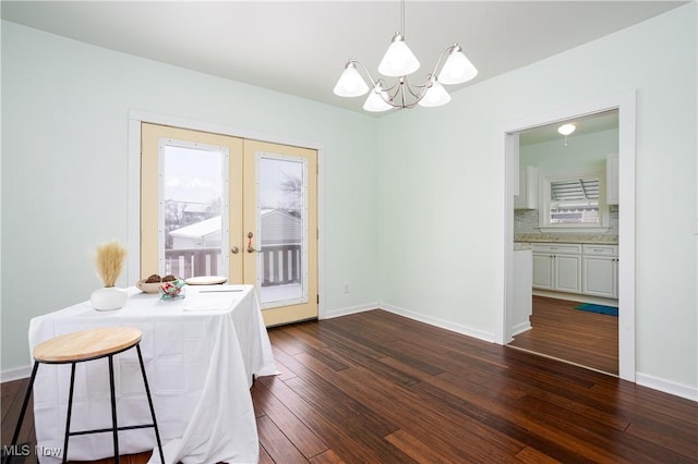 dining room featuring an inviting chandelier, dark wood-type flooring, and french doors