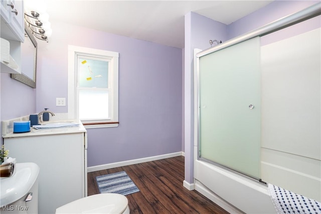 full bathroom featuring combined bath / shower with glass door, hardwood / wood-style floors, vanity, and toilet