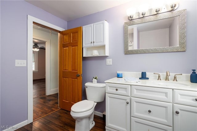 bathroom featuring wood-type flooring, vanity, toilet, and ceiling fan