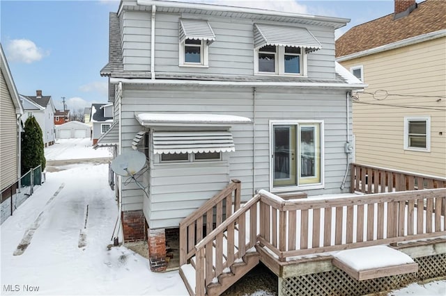 snow covered rear of property featuring a wooden deck