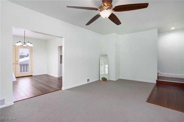 empty room with ceiling fan with notable chandelier and carpet floors