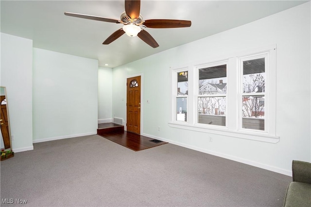 unfurnished living room featuring carpet floors and ceiling fan