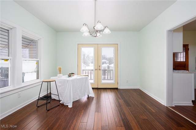 dining space with a chandelier, dark hardwood / wood-style floors, and french doors