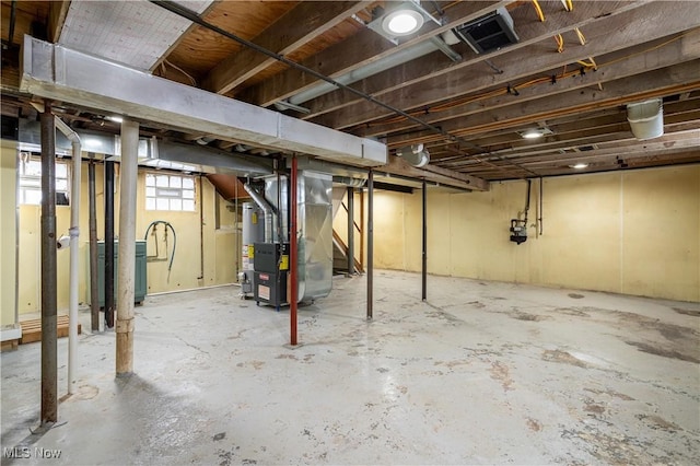 basement featuring gas water heater and heating unit