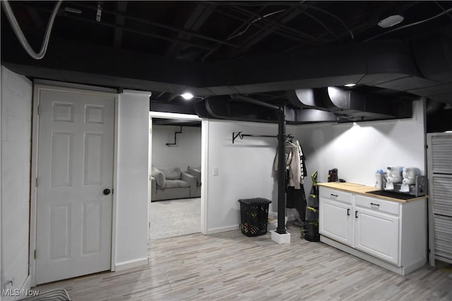 basement with light hardwood / wood-style floors