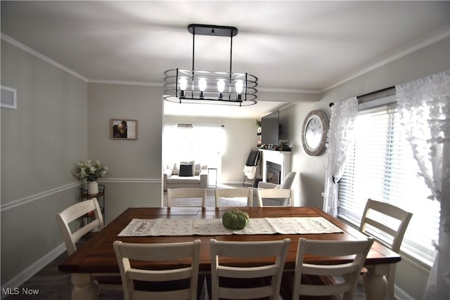 dining space with hardwood / wood-style flooring, an inviting chandelier, ornamental molding, and plenty of natural light