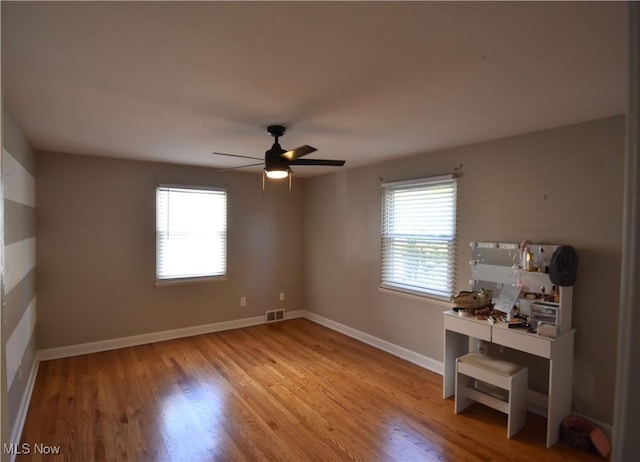 empty room with ceiling fan and light hardwood / wood-style flooring