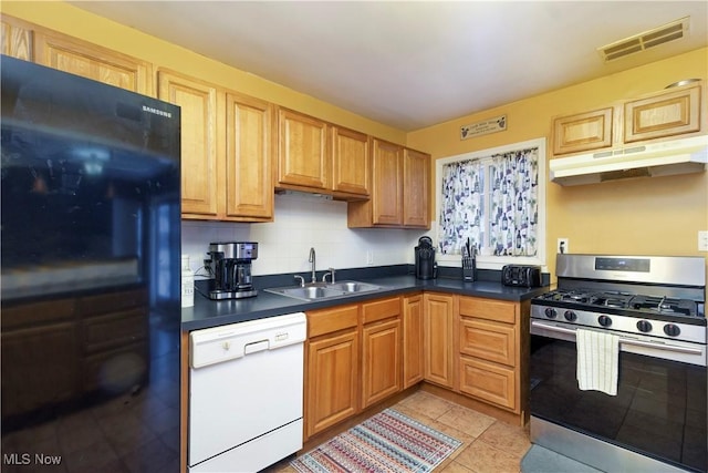 kitchen with dishwasher, sink, stainless steel gas range oven, black fridge, and decorative backsplash