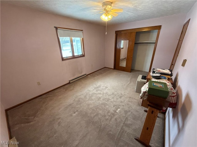 unfurnished bedroom featuring carpet, a textured ceiling, ceiling fan, a baseboard radiator, and a closet