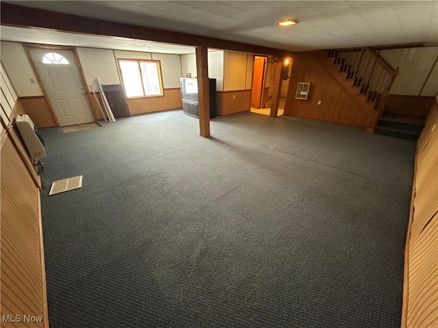 basement featuring carpet floors and wooden walls