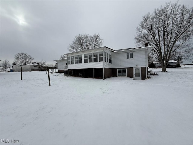 snow covered property with a sunroom