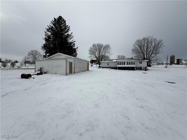 yard layered in snow featuring an outdoor structure