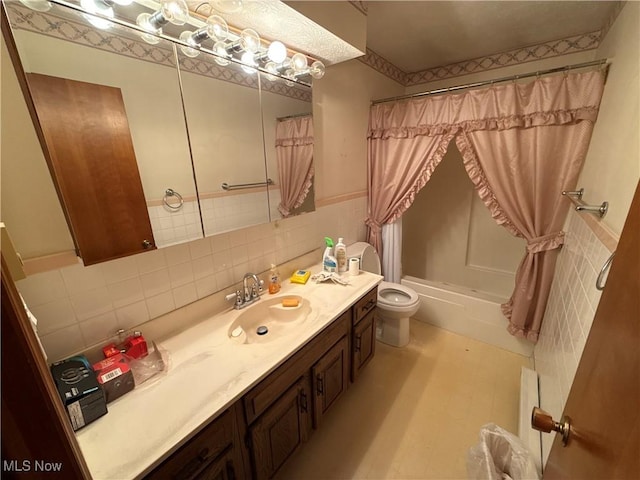 full bathroom with vanity, toilet, tile walls, and shower / tub combo