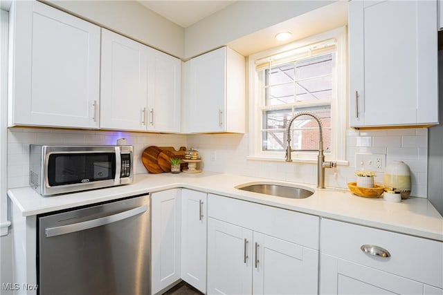 kitchen featuring white cabinetry, sink, appliances with stainless steel finishes, and tasteful backsplash