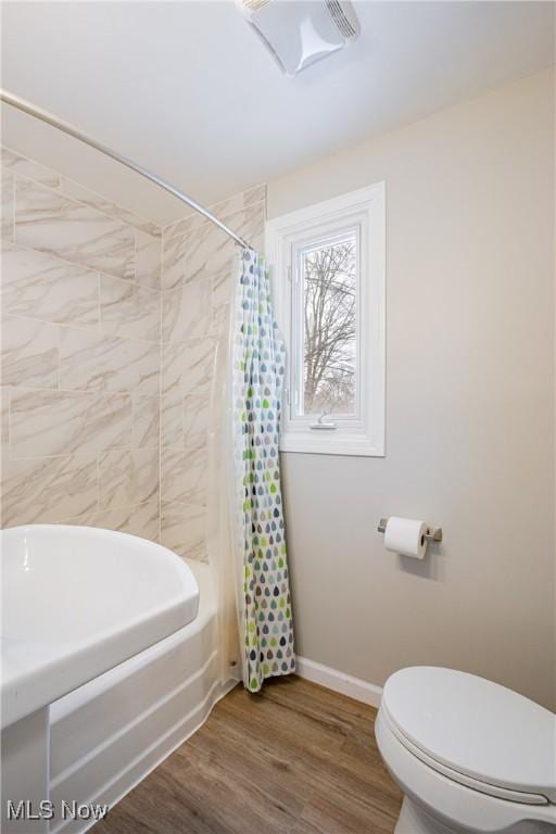 bathroom featuring wood-type flooring, toilet, and shower / bath combination with curtain