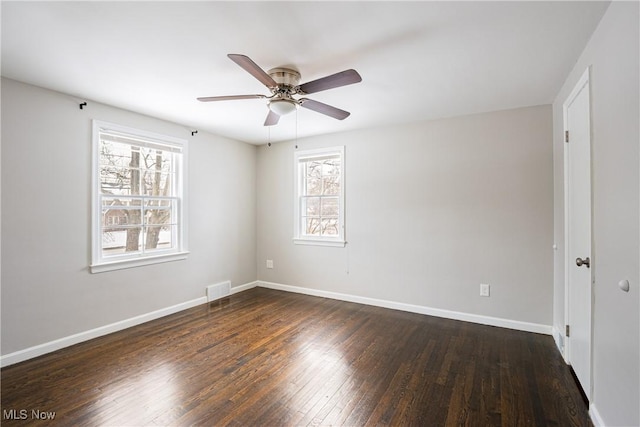 empty room featuring dark hardwood / wood-style flooring, ceiling fan, and plenty of natural light