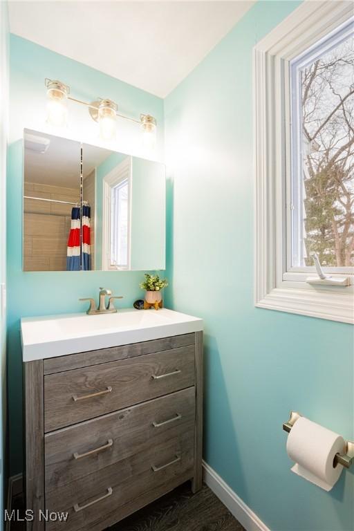 bathroom with a shower with shower curtain, vanity, and hardwood / wood-style flooring