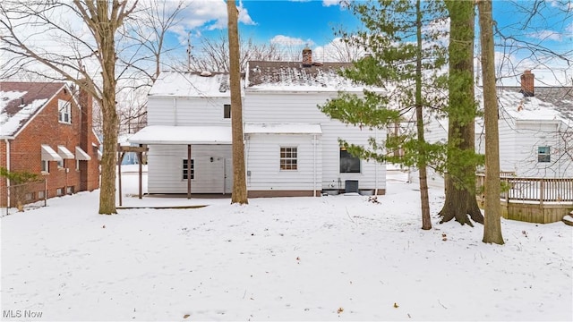 view of snow covered back of property