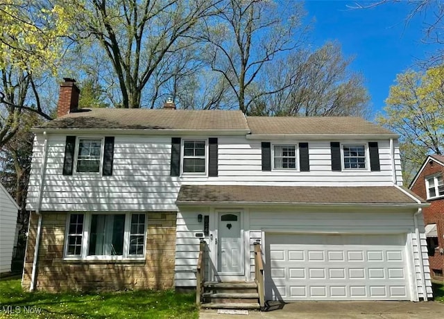 view of front of home featuring a garage, a chimney, and concrete driveway
