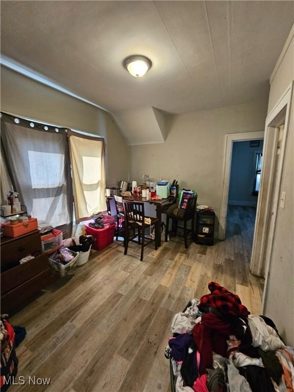 additional living space featuring lofted ceiling and light wood-type flooring