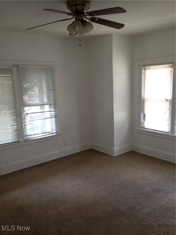 empty room featuring ceiling fan and carpet