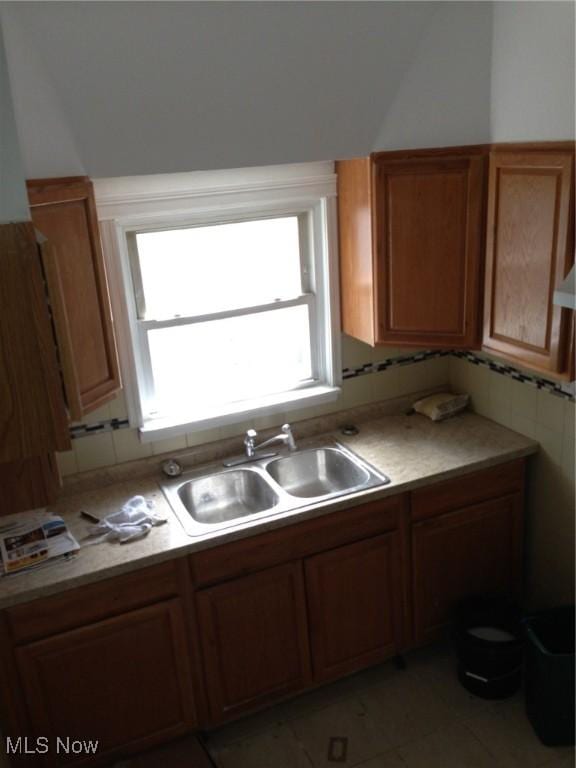 kitchen featuring sink, backsplash, and light tile patterned floors