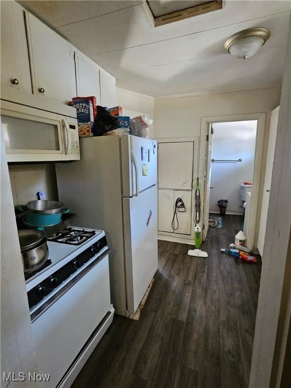 kitchen with white appliances, white cabinetry, and dark wood-type flooring