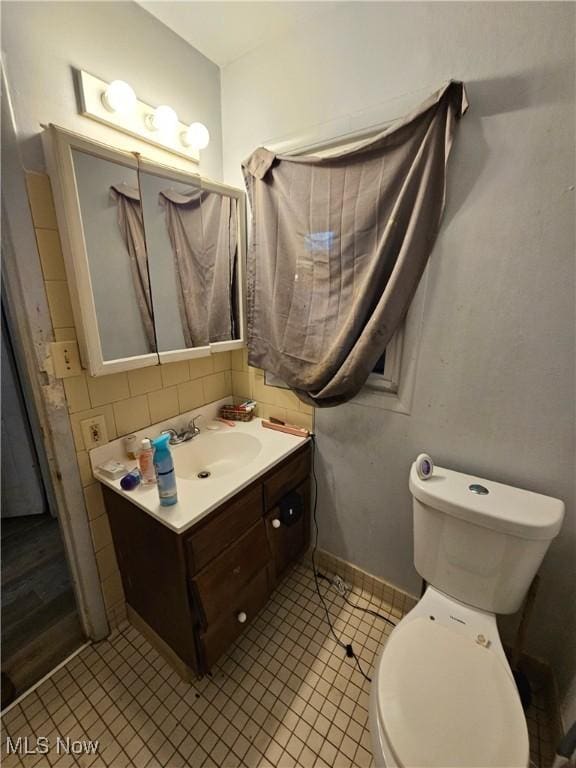 bathroom featuring vanity, toilet, tile patterned floors, and tasteful backsplash