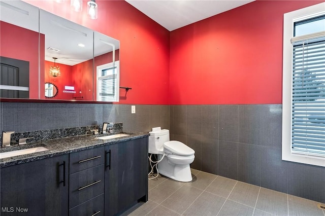 bathroom with tile patterned flooring, vanity, tile walls, and toilet