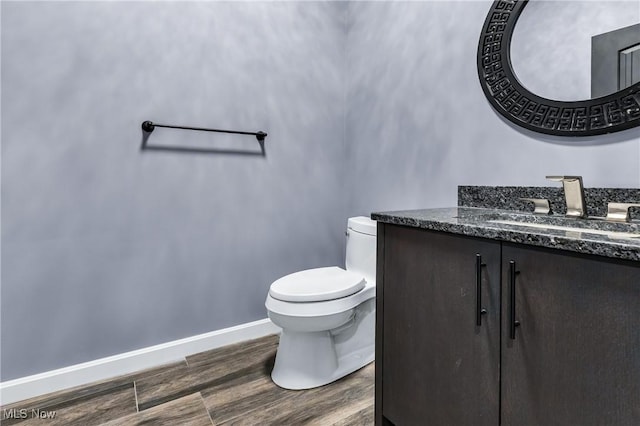 bathroom with hardwood / wood-style flooring, vanity, and toilet