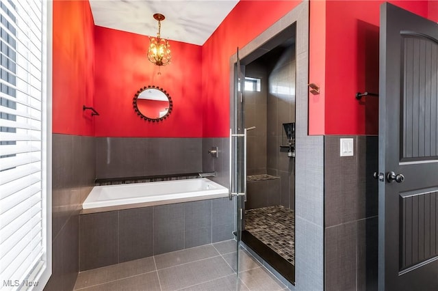 bathroom featuring plus walk in shower, tile patterned flooring, and a wealth of natural light