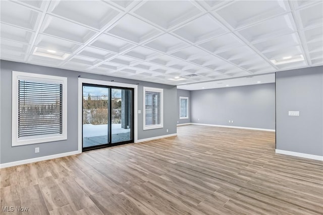 unfurnished living room featuring coffered ceiling and light hardwood / wood-style floors