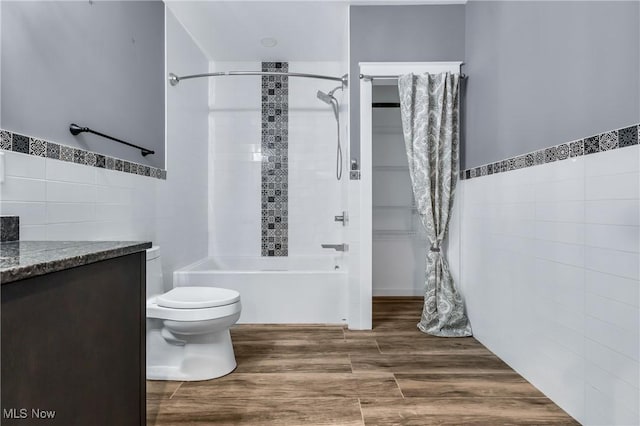 full bathroom featuring vanity, tile walls, shower / bath combination with curtain, and toilet