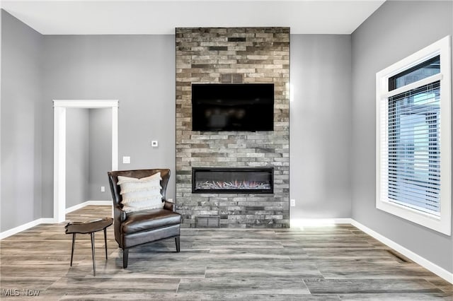 sitting room featuring a fireplace and wood-type flooring