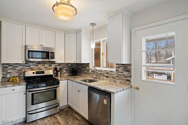kitchen featuring pendant lighting, sink, white cabinets, and stainless steel appliances
