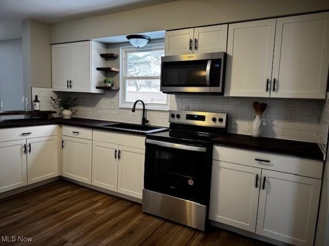 kitchen featuring white cabinets, decorative backsplash, stainless steel appliances, and sink