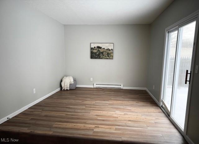 spare room featuring light wood-type flooring and a baseboard radiator