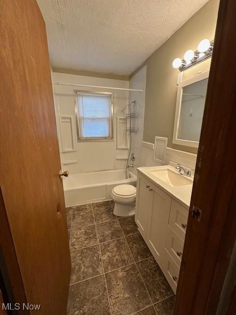 full bathroom featuring vanity, toilet, a textured ceiling, and shower / washtub combination