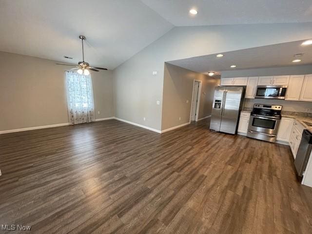 kitchen featuring white cabinets, dark hardwood / wood-style flooring, stainless steel appliances, and vaulted ceiling