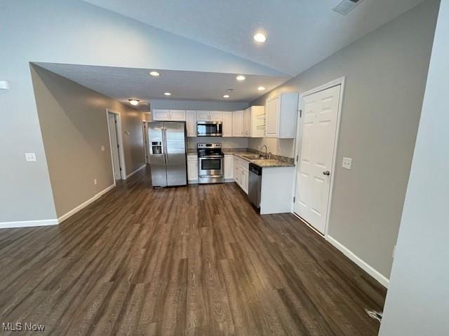 kitchen with lofted ceiling, sink, dark hardwood / wood-style flooring, white cabinetry, and stainless steel appliances