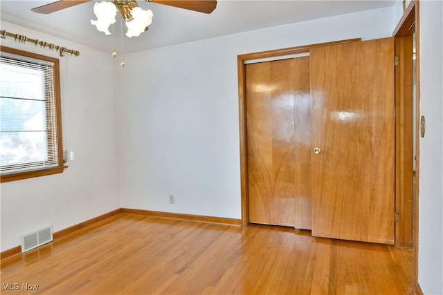 unfurnished bedroom with light hardwood / wood-style floors, a closet, and ceiling fan