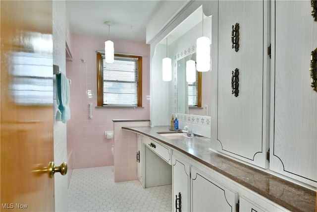 bathroom featuring vanity and tile walls