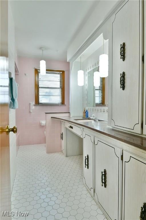 bathroom with tile patterned flooring, vanity, and tile walls