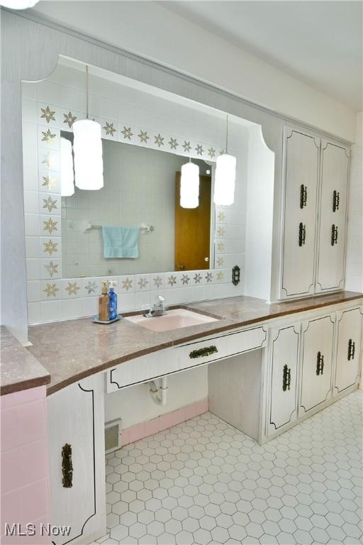 bathroom featuring vanity and backsplash