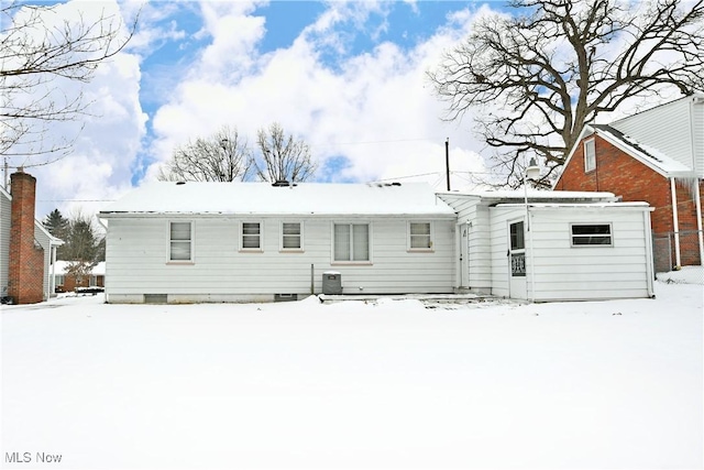 snow covered property with central AC unit