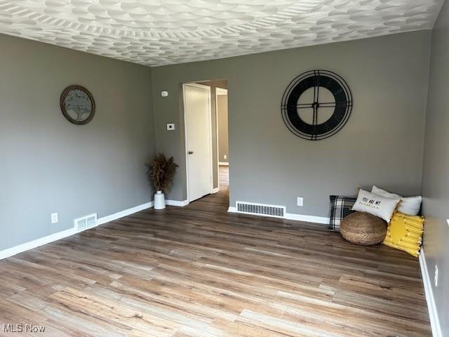 unfurnished room with hardwood / wood-style flooring