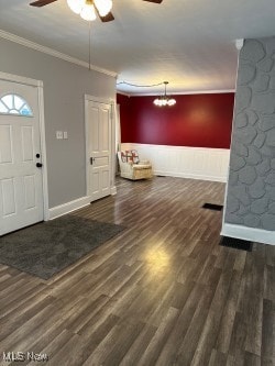 entryway with crown molding, dark hardwood / wood-style flooring, and ceiling fan with notable chandelier